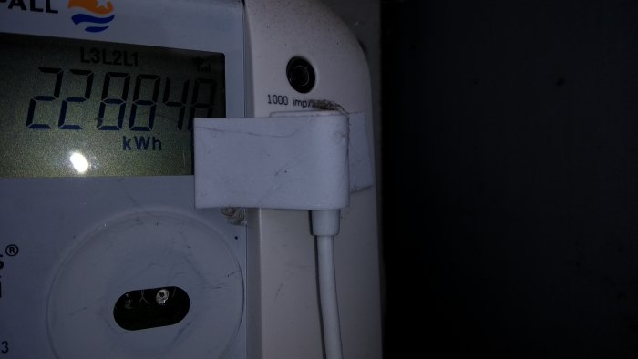 Elräknare vid 22084,9 kWh med Sparsnäs-tillbehör monterat på dess sida, använd för energiövervakning.