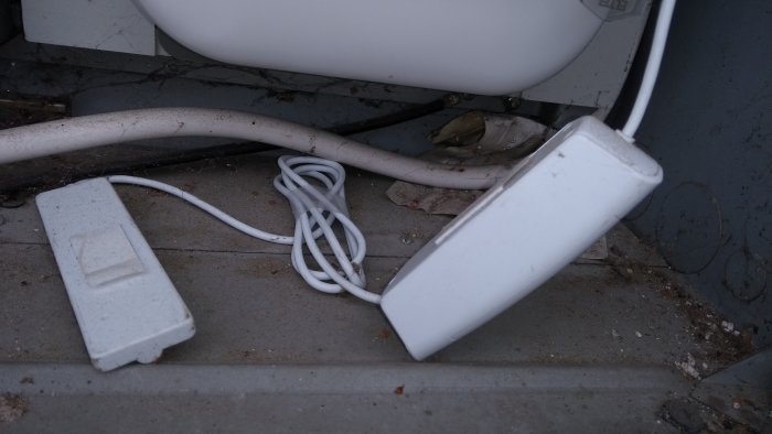 En energimätartillbehör, Sparsnäs, kopplat till en elektrisk ledning på betonggolv.