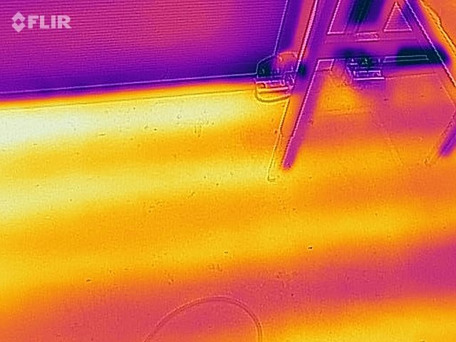 Termisk bild av en golvvärmeinstallation med möjlig läckagepunkt, märkt av färgvariationer.
