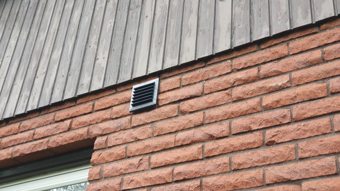 Plastventilationsgaller från Fresh på ojämn tegelvägg med glipor runt installationen.