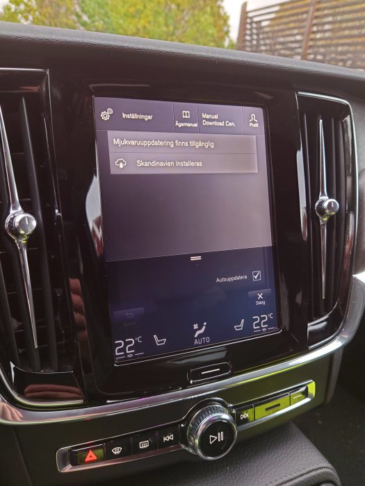 Bilens infotainmentsystem visar skärm för mjukvaruuppdatering med text "Skandinavien installeras".
