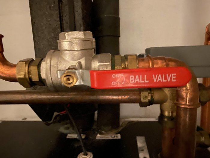 Rörkopplingar och en röd kulkran markerad med "ON/OFF BALL VALVE" inom uppvärmningssystem.