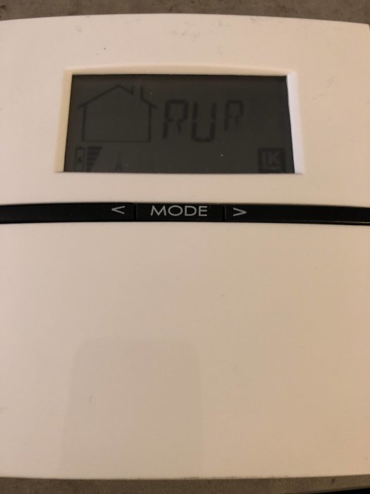 Trådlös termostat med otydlig display och synligt slitage, möjligtvis skadad av batteriläckage.