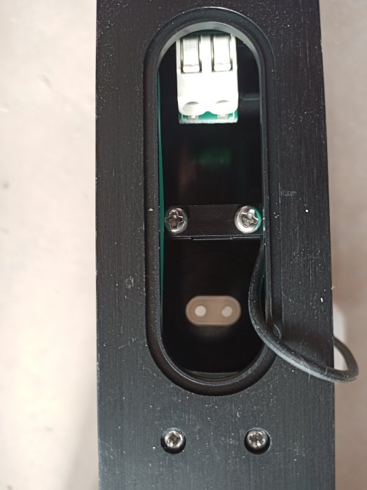 Bakre delen av en INR Bow handdukstork med synlig anslutning och en utstickande elkabel.