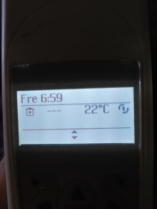 Display på fjärrkontroll som visar temperaturen 22 grader Celsius och klockan 6:59.