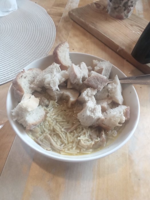 En skål med kyckling och curry soppa toppad med bitar av vitlöksbröd, serveras som födelsedagslunch.