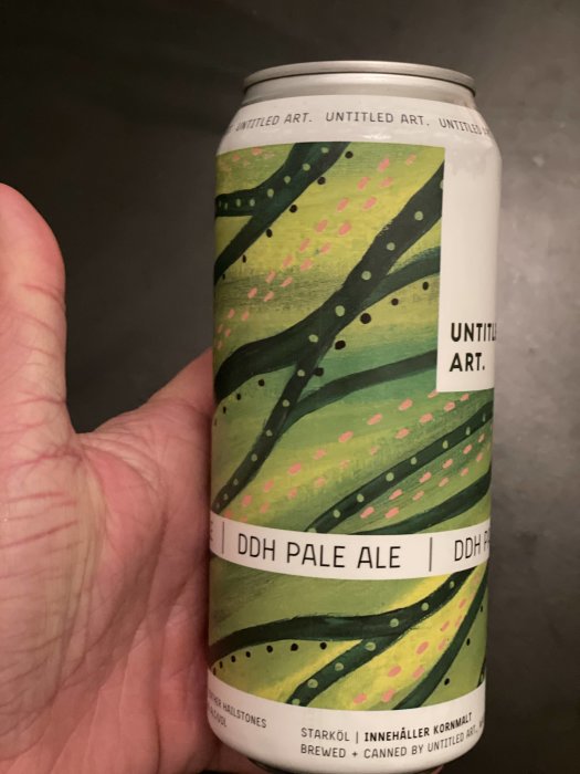 Hand håller en burk DDH Pale Ale från Untitled Art med konstnärlig etikett.