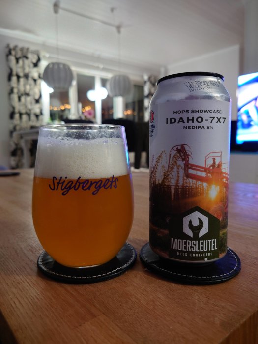 Ett glas öl från Stigbergets och en burk Moersleutel öl på ett bord med suddig bakgrund.