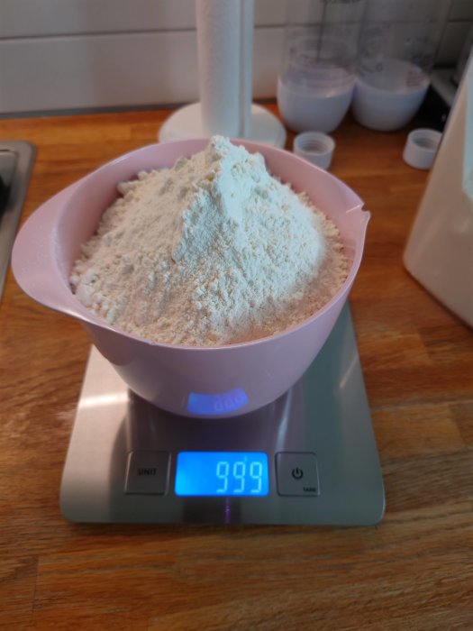 En skål med mjöl på en digital våg som visar 999 gram.