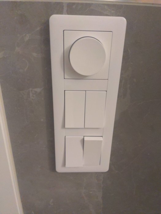 Dimmer och strömbrytare på kakelvägg i badrum med potentiell blinkande LED-problem.