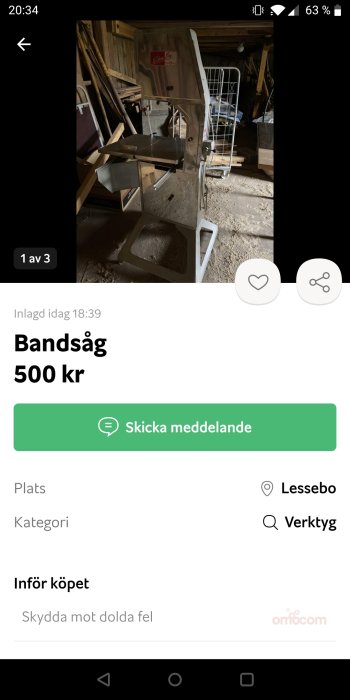 Bandsåg för kött placerad i ett rörigt garage.