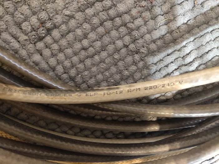 Defekt värmekabel med texten "Ericsson Cables S ELP 1*1/2 MM 220-240V" mot en texturerad bakgrund.