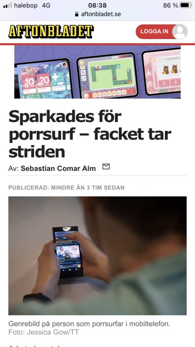 Person som håller en mobiltelefon med innehåll som inte kan visas tydligt.