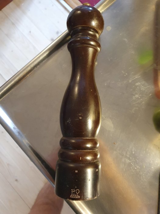 En dammig pepparkvarn från Peugeot på en rostfri yta, inköpt 2010, med synliga slitage.