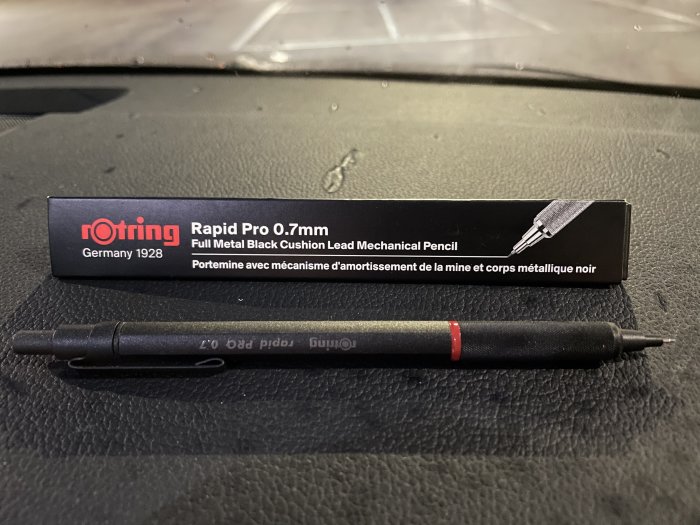 Rotring Rapid Pro 0.7mm mekanisk penna och förpackning på en svart yta.