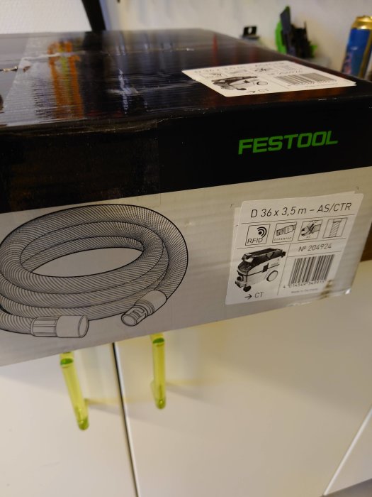 Oöppnad låda av Festool dammsugarslang med etikett och RFID-märkning.