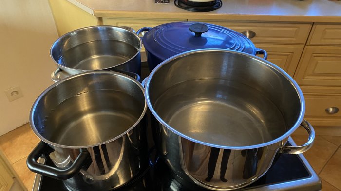 Fyllda grytor placerade på spishäll för att trycka ner silikon under härdning.