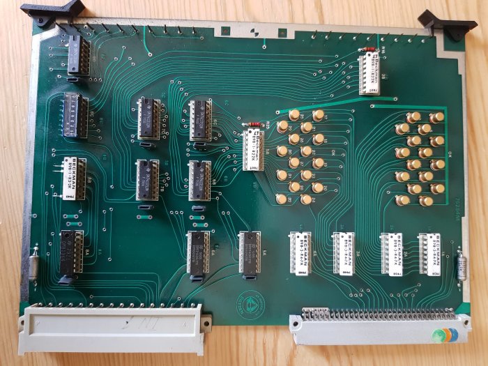 Ett välbevarat kretskort med olika elektroniska komponenter såsom integrerade kretsar och resistorer, några märkta Bofors och Telefunken.