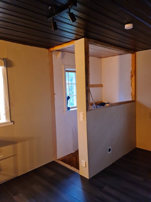 Trappkonstruktion under arbete i ett hem med osatt sättsteg och oavslutade väggpaneler.