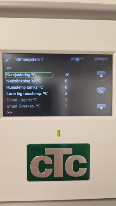 Display på värmepump med inställningar för kurvjustering och temperaturminskning.