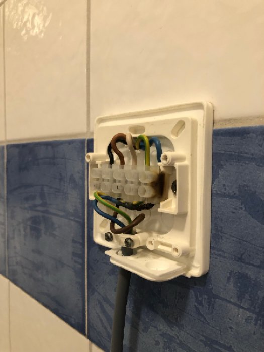 Elektrisk anslutningsdosa med brännskada vid nollans kabel i vägg.