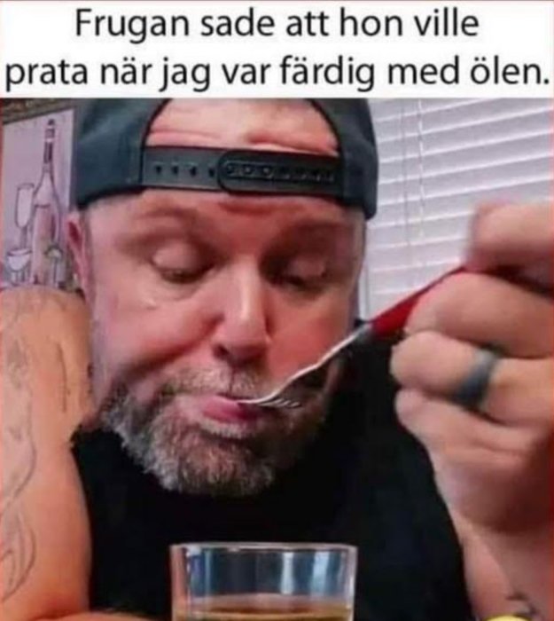 Man med keps äter med en sked och ser fundersam ut med en text om ölen och frugan.