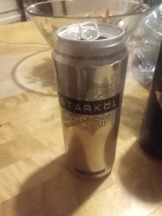 En öppnad ölburk med texten "Starköl" på en träyta.