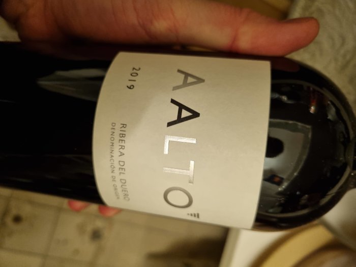 Hand håller en flaska Aalto Rioja från 2019.