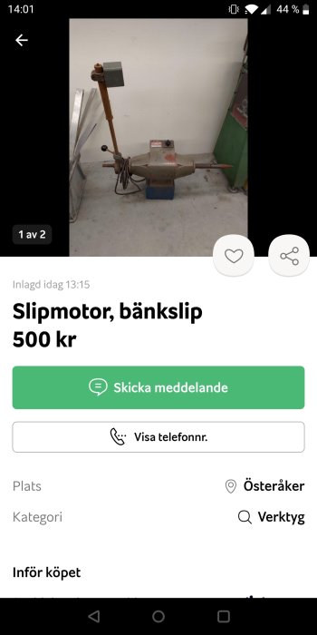 Begagnad bänkslipmaskin med slipsten och upprättstående belysningsarm i ett verkstadsrum.