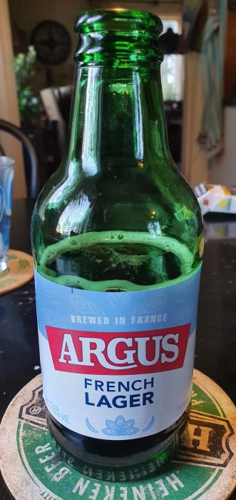 Flaska av ARGUS French Lager från Lidl, står på en ölunderlägg.