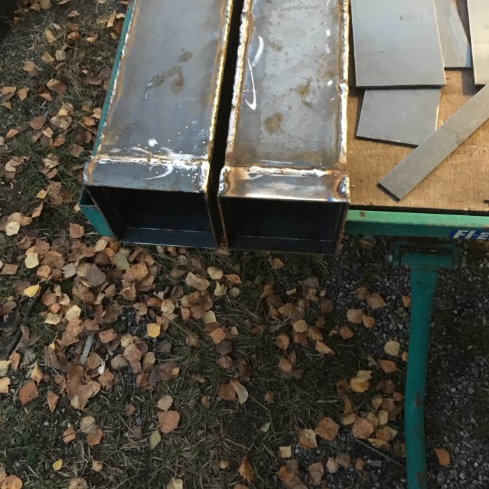 Stålbalkar på en arbetsbänk med svetsfogar, redo för borrning inför installation.