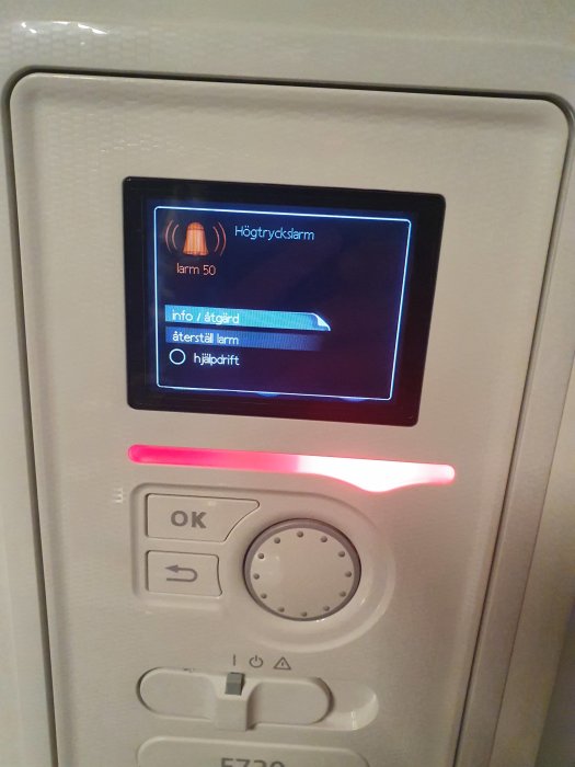 Värmepumpens display visar ett högtryckslarm med texten "larm 50" och en röd varningslampa.