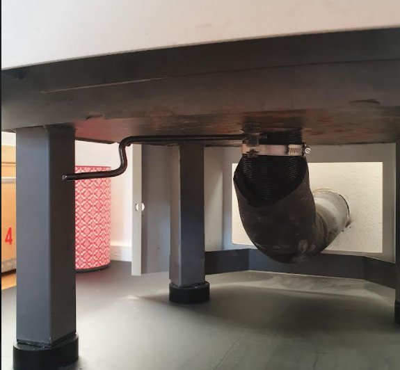 Undersidan av en äldre contura kamin med synlig ledarm och delvis öppen spjällmekanism.