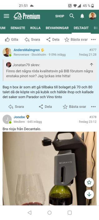 Coravin vinsystem används på en öppnad flaska vin bredvid ett glas med rödvin.