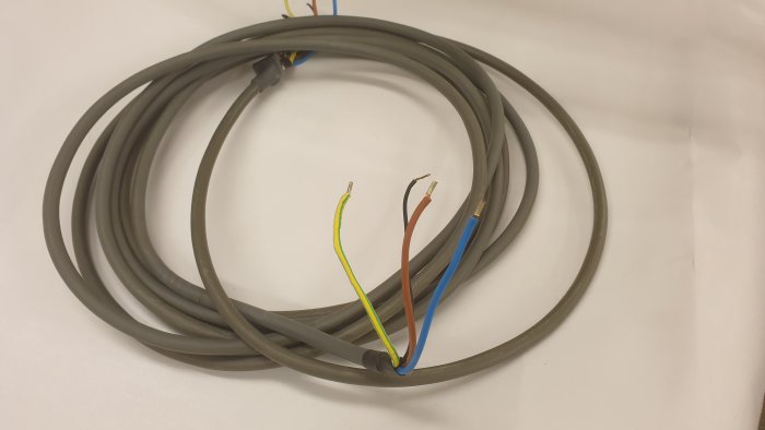 7,5 meter grå el-kabel från Charge-Amps ligger upprullad med synliga ledarändar i gult, brun, blått och jord.