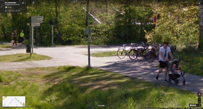 Smal gång- och cykelväg med person som går med barnvagn, parkerade cyklar, och ingen tydlig separation.