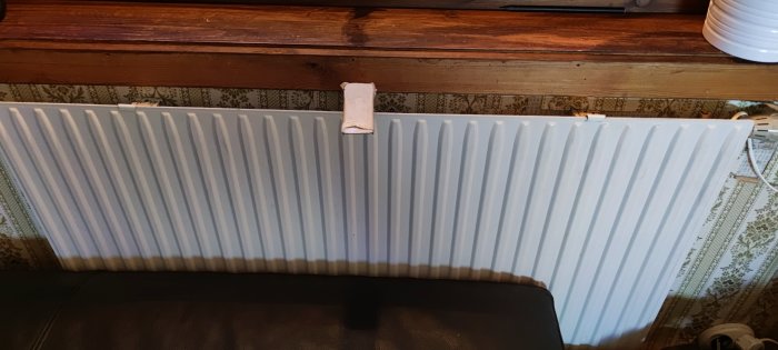 Ett element framför en vägg med gamla kakelplattor och en träfönsterbräda som användaren planerar att ta bort.