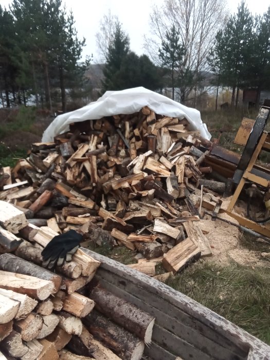 Vedtrave täckt med presenning i en gammal träsläde, med en handske framtill.