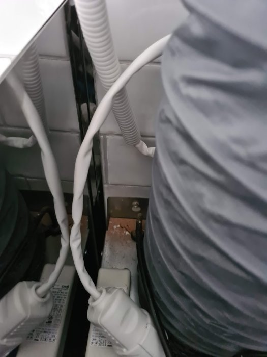 Inre vy av en fläktkåpa med lösa sidor och synliga skruvar utan tydliga fästpunkter.