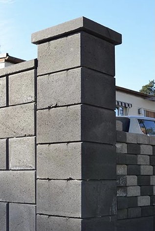 Sprucken betongpelare på mur, möjlig reparation med betongspackel.