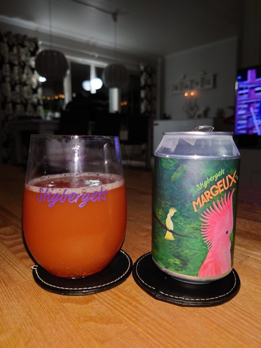 Ett glas med Stigbergets öl och en burk öl märkt "Margaux" på ett vardagsrumsbord.