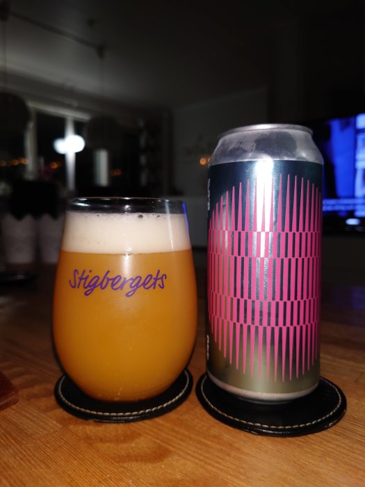 Ölglas med skumfylld dryck och en ölburk med grafiskt mönster, båda betygsatta 4.0/5.