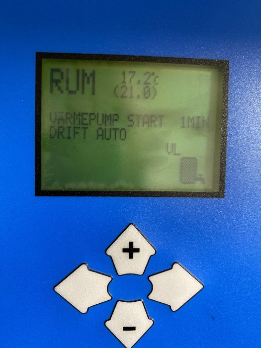 Display av värmepumps kontrollpanel som visar rumstemperatur och driftsstatus.