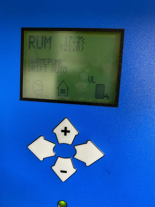 Display på värmepump som visar rumstemperatur och driftsläge med knappar för inställning.