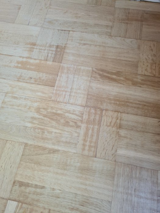 Slipad ekparkett med ojämn absorption av hårdvaxolja vilket ger fläckigt utseende.