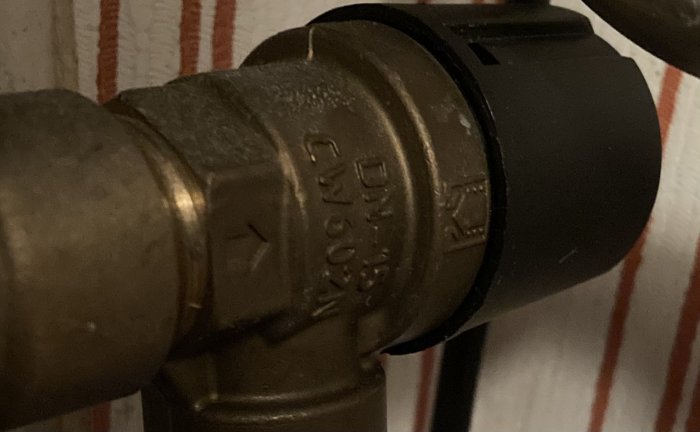 Närbild på en mässingsventil med texten "DN15 CW617N" graverad på sidan.