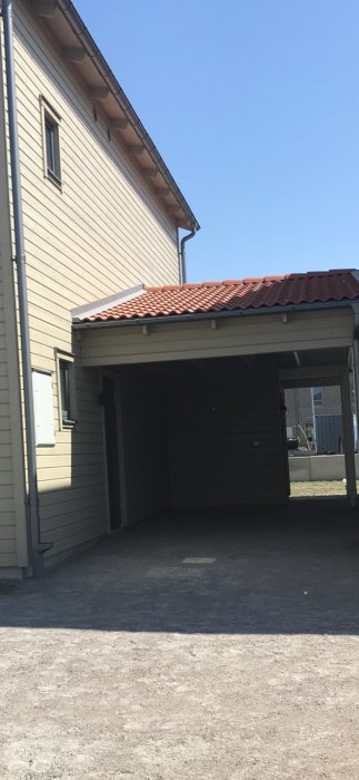 Carport med anslutning till husets sidopanel där vattenläckage problemet beskrivs.