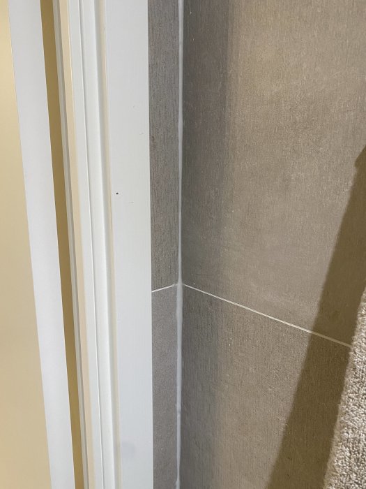 Otillfredsställande silikonfog mellan kakelvägg och dörrkarm i gästtoalett.