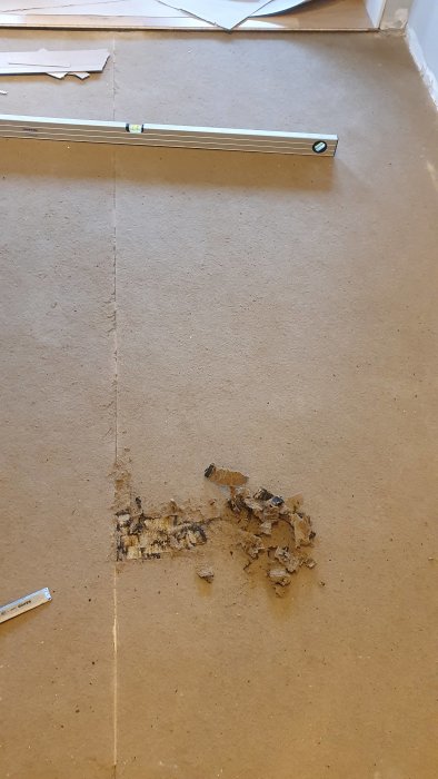 Ett ojämnt golv med rester av lim och borttagen linoleummatta, fråga om möjlighet att flytspackla för utjämning.