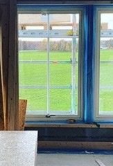Utsikt från ett oinrett rum med långa nära-golv-till-tak-fönster och synlige radiatorutrymme.